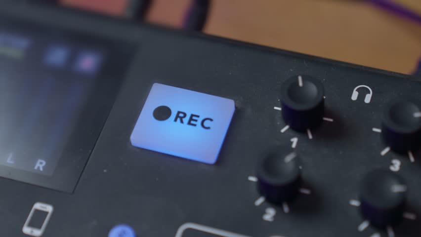 Hand pressing on REC button to begin recording and then clicking again to stop audio session. Sound and audio console detail or close up. Engineer or podcast host in home or professional sound studio