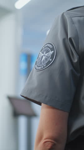 Security Checkpoint in Airport: Female Security Officer Checks Female Passenger Body for Dangerous Items After Metal Detector Scanner. TSA Screening Procedures. Traveler Going on Trip. Vertical Shot.