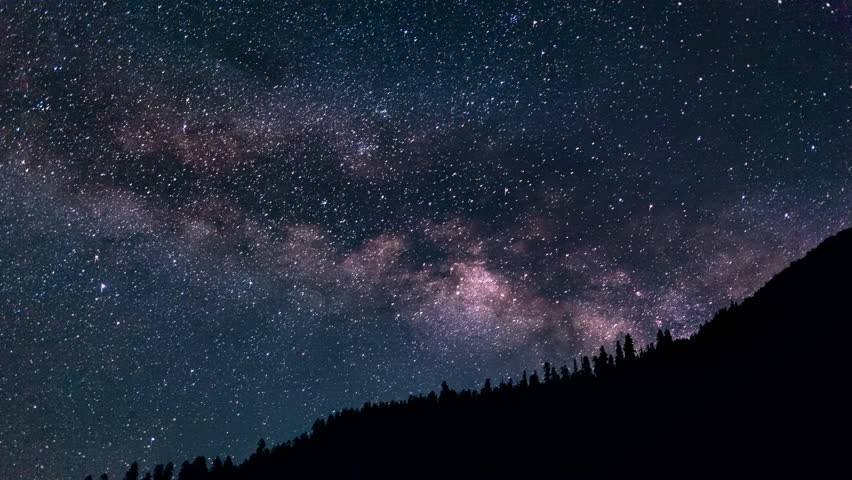 Time lapse video of milk way galaxy crossing over mountains ridge in the night sky.