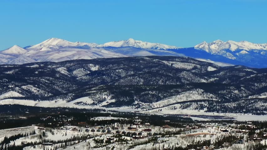 Colorado Rocky Mountain National Park Fraser downtown Winter Park ski resort mountain town aerial drone Grandby Grand Lake winter December snow blue sky sunny blanket of snow circle left motion