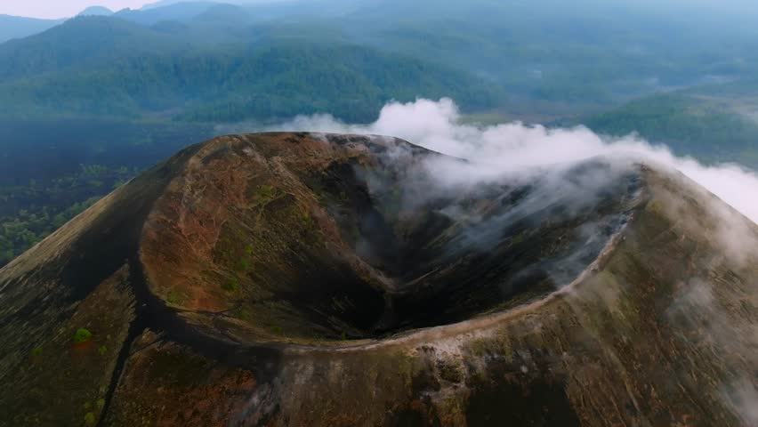 A breathtaking cinematic aerial panoramic view of Paricutin Volcano in Michoacan, Mexico, surrounded by ethereal clouds. A majestic display of nature's raw power and serene beauty.