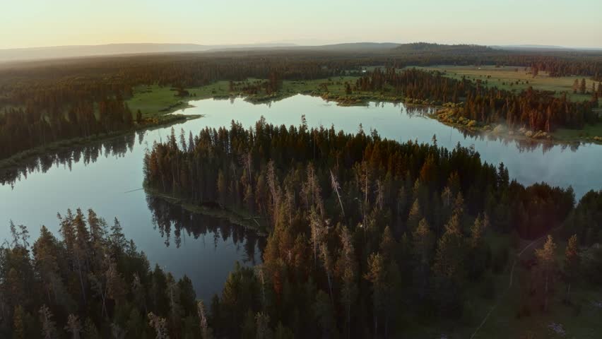 4K Drone footage of birds flying at sunrise over winding river of Henrys Fork Idaho river and Fish Pond lake