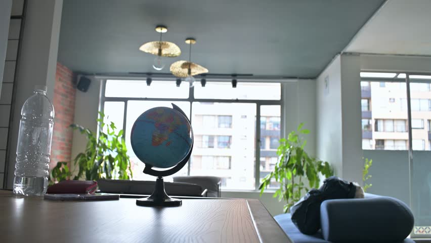 Women taking backpack, wallet and water bottle for leaving apartment, globe on table, window at background