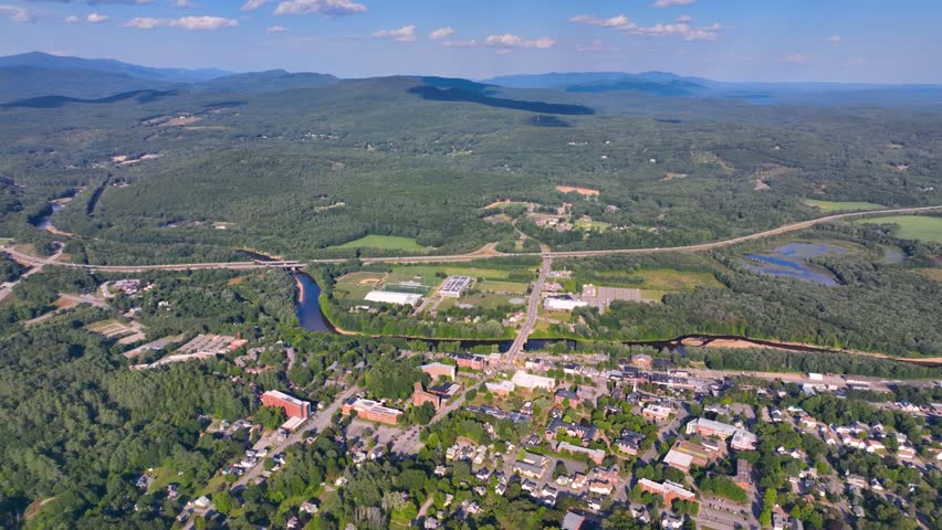Plymouth State University and Pemigewasset River aerial view with White Mountain National Forest at the background in summer in historic town center of Plymouth, New Hampshire NH, USA. 