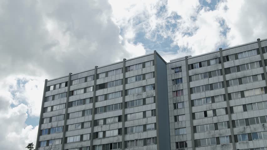 Wide shot of social housing buildings in Nieuw Gent, Belgium, under a cloudy sky, reflecting urban life