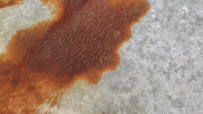 Rough rusty metal or zinc. This metal rusts due to exposure to sunlight and rainwater.