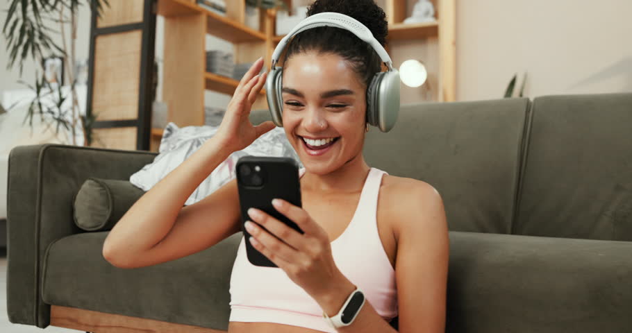 Happy woman, fitness and listening with headphones for audio streaming, music or podcast at home. Active, female person or smile with mobile smartphone for online subscription or radio app at house