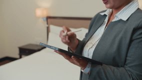Cropped copy space shot of female manager checking hotel room readiness and using digital tablet - Powered by Shutterstock - Get 15% off with code: PIKWIZARD15