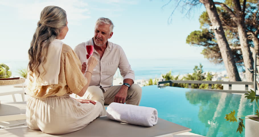 Couple, drinks or toast by swimming pool on holiday, vacation or celebrate love on valentines day date. Cocktail, senior man and woman cheers at resort outdoor for peace, happy or relax in retirement