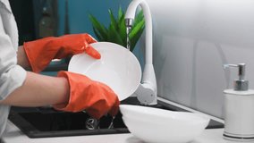 housework, young housekeeper in protective gloves rinsing foam from detergent from dishes under water in kitchen sink, close-up - Powered by Shutterstock - Get 15% off with code: PIKWIZARD15