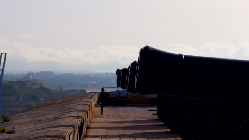 A closeup of a cannon launch a bomb with smoke with gray sky