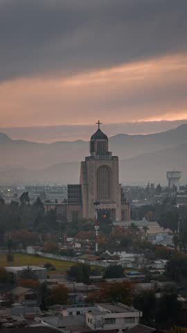 A drone timelapse of the cityscape in front of Maipu Votive Temple at sunset during autumn in Santiago, Chile