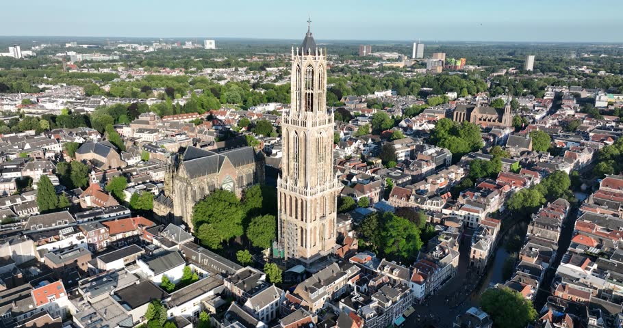 An aerial view of the Dom Tower in the middle of Utrecht buildings on a sunny day with blue sky in Netherlands