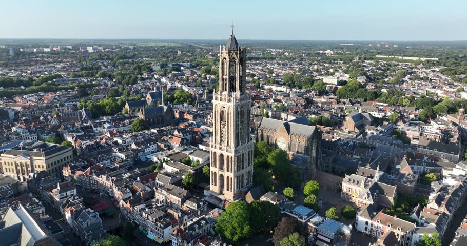 An aerial view of the Dom Tower in the middle of Utrecht houses on a sunny day with blue sky background in Netherlands