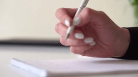 Close-up of a businesswomans hand writing notes in a notebook during corporate planning and strategy - Powered by Shutterstock - Get 15% off with code: PIKWIZARD15