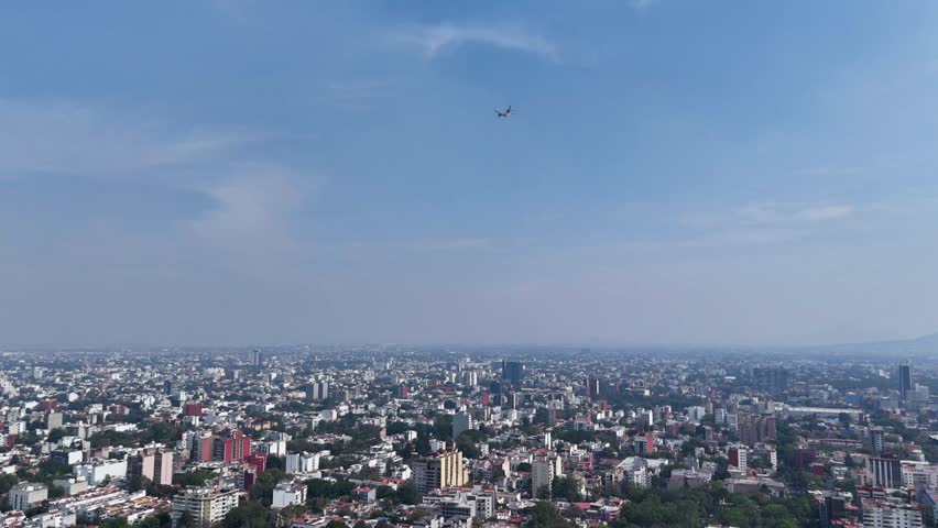 Still frame capturing a plane flying over Mexico City