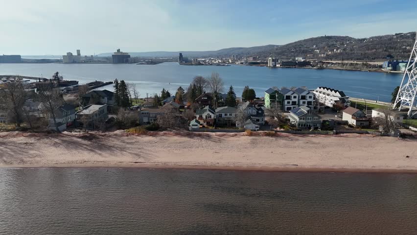 Drone Flying Parallel to Beach. moving past houses and trees. Park Point In Duluth Minnesota. Lake Superior