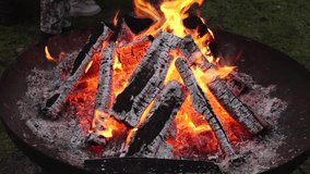 A burning bonfire with glowing logs at night, surrounded by people in warm clothing during a solemn gathering. The scene captures a sense of community and reflection. - Powered by Shutterstock - Get 15% off with code: PIKWIZARD15