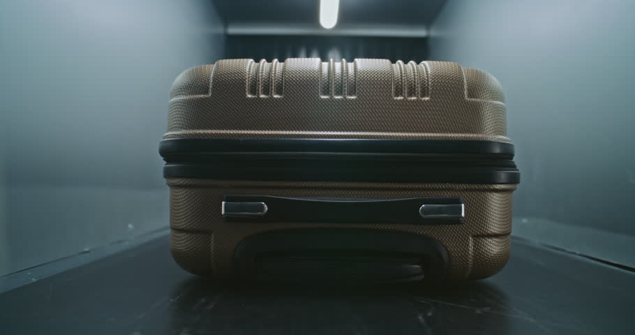 Security Checkpoint in Airport Terminal: Close Up of Passenger Suitcase Moving on Conveyor Belt Inside Advanced Metal Detector X-ray Scanner. Baggage Screening, Monitoring Procedure for Plane Flight.
