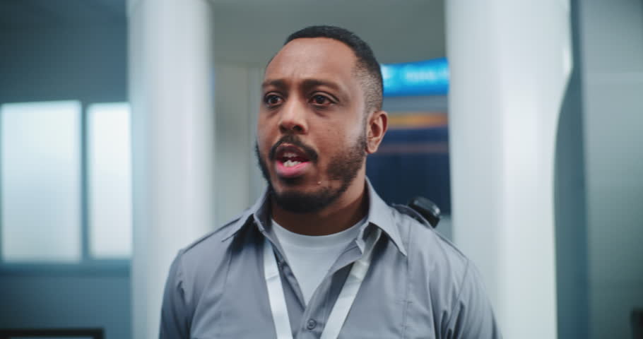 Airport Security Check: African American Security Officer Gives Instructions to Diverse People, Passengers About TSA Screening Procedures for Plane Flight. Tourists Going on Vacation Trips. Dolly Shot