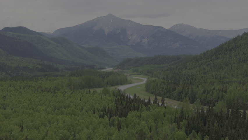 Towering mountain ranges rise above Yukon’s green landscape