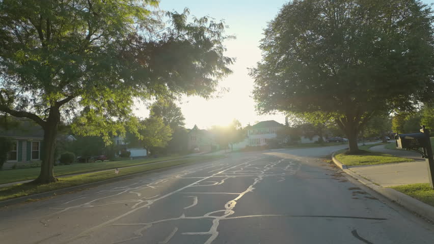 POV wide shot of suburban street in USA neighborhood on a beautiful sunny day. shot in moving car