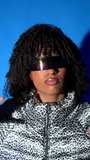 Futuristic fashion model wearing high tech visor and reflective jacket, standing confidently in luminous blue studio environment, embodying cutting edge style and technological innovation - Powered by Shutterstock - Get 15% off with code: PIKWIZARD15