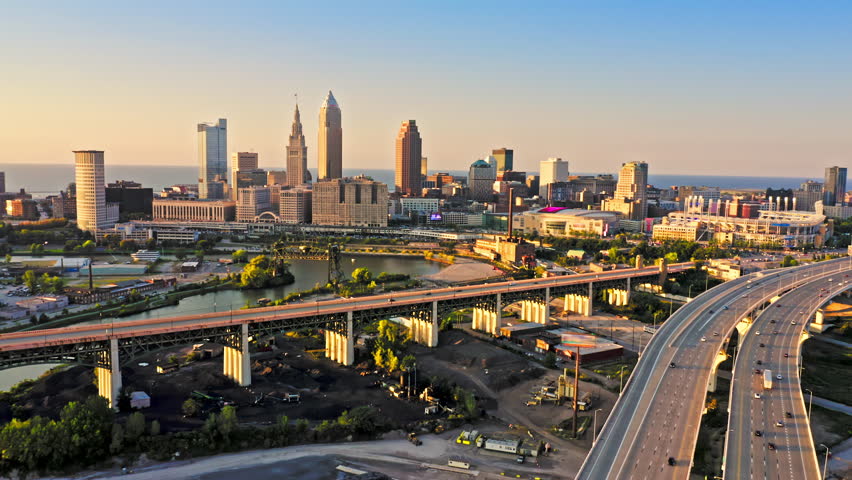 Aerial view of Cleveland, Ohio skyline and I90 interstate highway at sunset with slow camera uptilt. Cleveland is a major city in the U.S. state of Ohio and the county seat of Cuyahoga County.