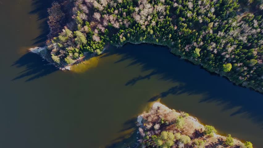 A drone shot of a boat going through a tight passageway in Northern Ontario