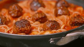 Overview of Delicious Italian Meatballs with Spaghetti Pasta in Rich Tomato Passata Sauce with Herbs with Wooden Spoon. Homemade Cooking Food Footage. - Powered by Shutterstock - Get 15% off with code: PIKWIZARD15