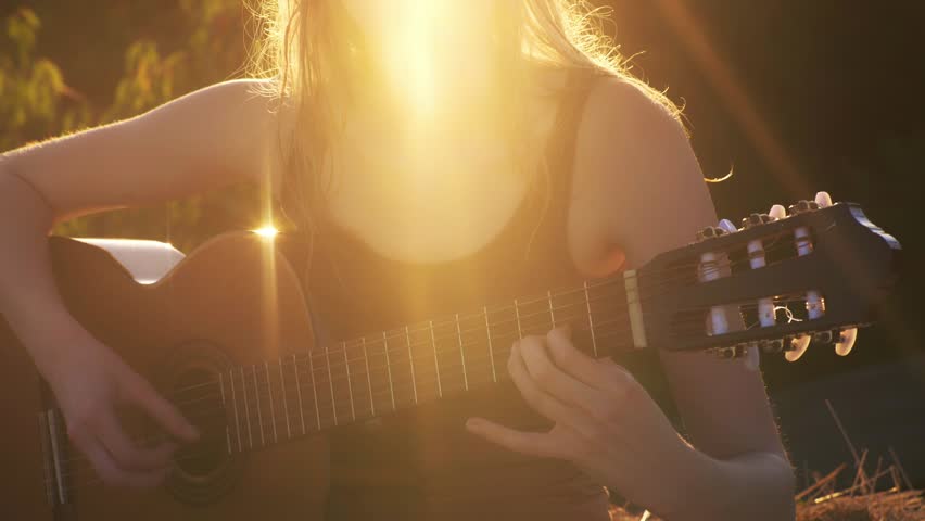 Girl playing Guitar on sunset. Romantic woman with a guitar. Beautiful singer outdoors. Talented guitarist. Sensual musician. Sensual woman with a guitar. Artistic woman playing music. Female