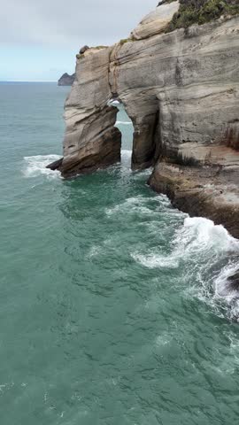 A drone view of the rocky coastline of Cape Farewell headland overlooking ocean on the South Island in New Zealand