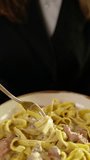 Close-up slow motion capturing female hand twirling spaghetti around fork, spinning pasta with delicate movement while experiencing elegant italian culinary indulgence - Powered by Shutterstock - Get 15% off with code: PIKWIZARD15