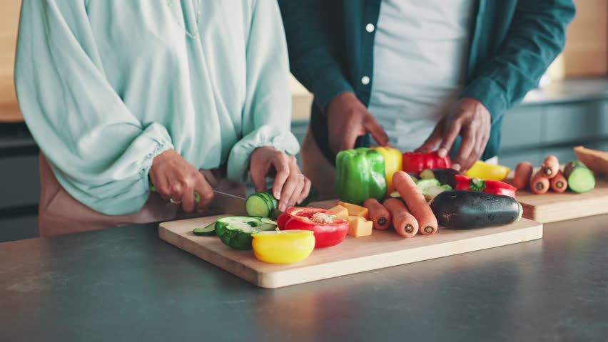 Kitchen, couple and hands with vegetables for cooking, nutrition and bonding together at home. House, man and woman with food for meal prep, healthy diet and support in marriage for dinner by closeup