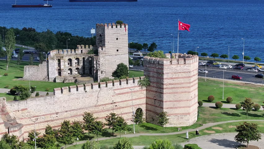 Drone view of a historic fortress in Istanbul with green spaces and a coastal road by the sea, oe01