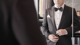 Close up young adult happy man asia people prepare clothes for tied knot wedding life event party get dressed up wear cuff link bow tie try on full male suit at fitting room modern luxury shirt store. - Powered by Shutterstock - Get 15% off with code: PIKWIZARD15