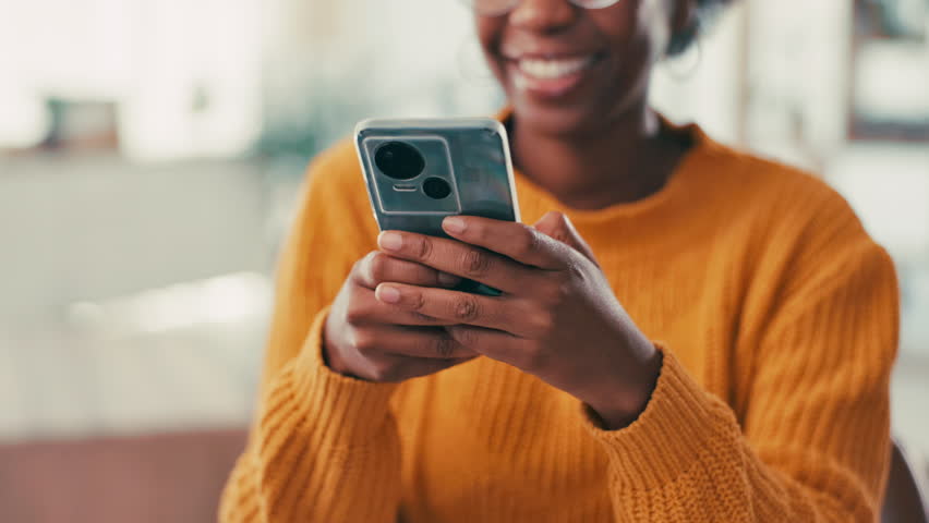 Black woman, hands and typing with phone for social media, network or communication at home. Closeup, female person or user with smile on mobile smartphone for new app, texting or chatting at house