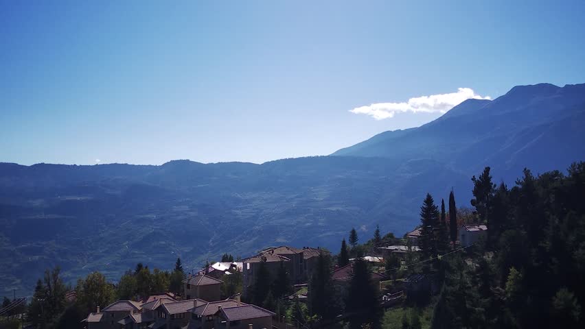 A drone footage of hillside luxurious houses surrounded by lush green vegetation