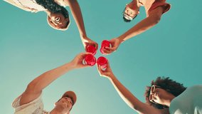 Friends, happy and cheers drinks with celebration for beach party, holiday reunion and summer adventure. Low angle, blue sky and people in circle with alcohol cups for toast, social event and bonding - Powered by Shutterstock - Get 15% off with code: PIKWIZARD15