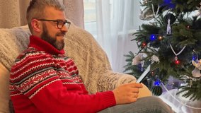 Cozy moments by the Christmas tree while reading an e book in an armchair - Powered by Shutterstock - Get 15% off with code: PIKWIZARD15