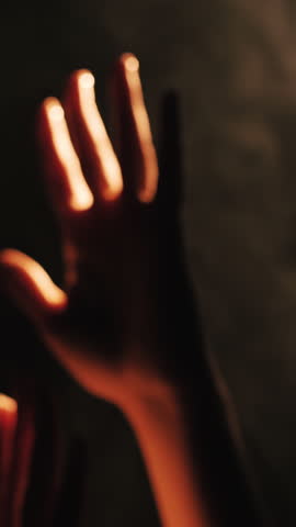 Hand reaching towards light in smoky atmosphere