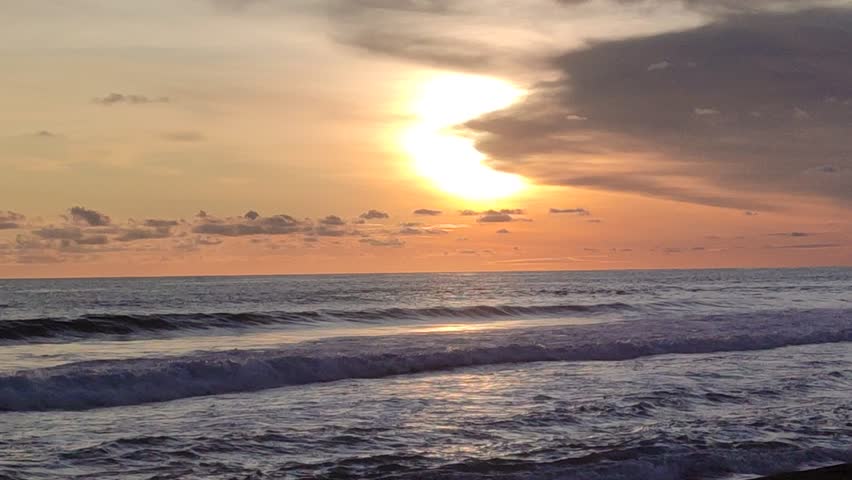 Sunset in the glagah beach, kulon progo, indonesia. Little cloudy on sky and some ocean wave