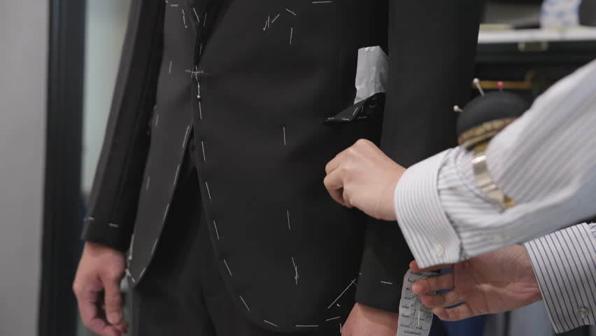 Close up young adult happy man asia people prepare custom tailoring made clothes for wedding party get dressed up tape scale measure try on full male suit at fitting room modern luxury shirt store.