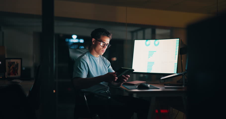 Laptop, night and tablet with business man in office for deadline, planning or research. Computer, investment and screen with international stock market trader in workplace for financial investment