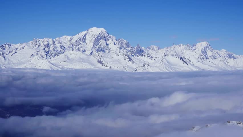A time-lapse footage of the dense clouds moving around Mont Blanc snowy peak on a sunny day in the Alps of Western Europe
