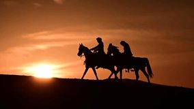 A Saudi rider gracefully moves through the golden desert on an Arabian horse, silhouetted against the stunning sunset. The scene captures the beauty of tradition, freedom, and the timeless bond  - Powered by Shutterstock - Get 15% off with code: PIKWIZARD15