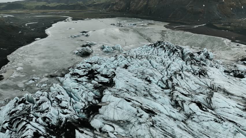 A drone view on a glacier surrounded by rugged mountains in the South of Iceland