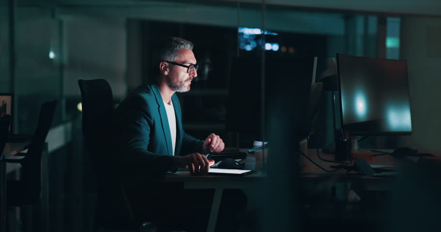 Coffee, night and technology with business man in office for deadline, planning or research. Computer, drink and tablet with international stock market trader in workplace for financial investment