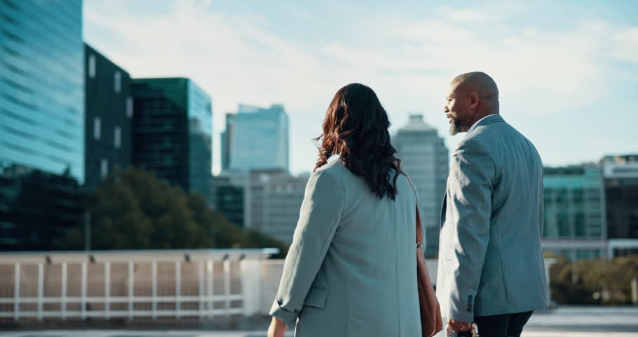 Business, people and walk of conversation in city for morning commute, journey and travel together. Back, man and woman talking with corporate movement, work trip and partner networking in urban town