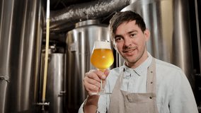 A brewer carefully examines a glass of craft beer in a professional brewing facility, showcasing craftsmanship and quality control in the beverage industry amidst stainless steel equipment and ferment - Powered by Shutterstock - Get 15% off with code: PIKWIZARD15